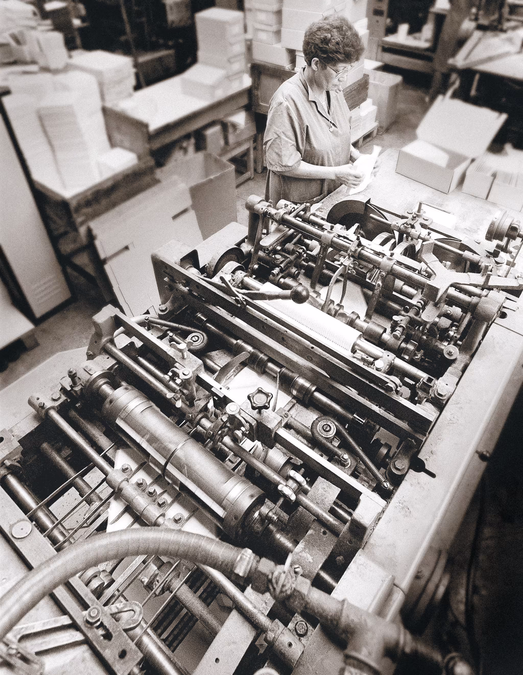 Arbeiterin inspiziert Motoren in einer Fabrik, Schwarz-Weiß-Foto aus industrieller Fertigung.
