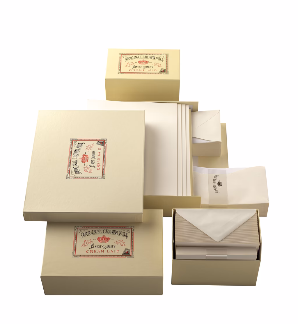 Elegante Briefpapier-Set "Original Crown Mill" mit cremefarbenen Boxen, Umschlägen und gestapelten Blättern.
